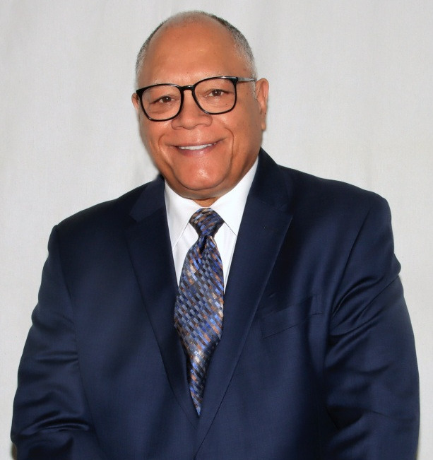 Jim Anderson wearing a blue suit with a red tie