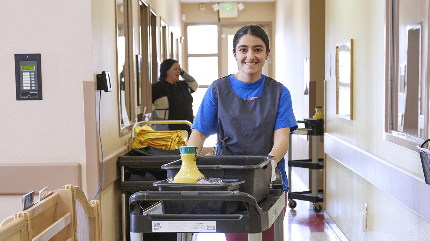 A female student successfully fulfills her duties in delivering snacks in the children's center during her internship.